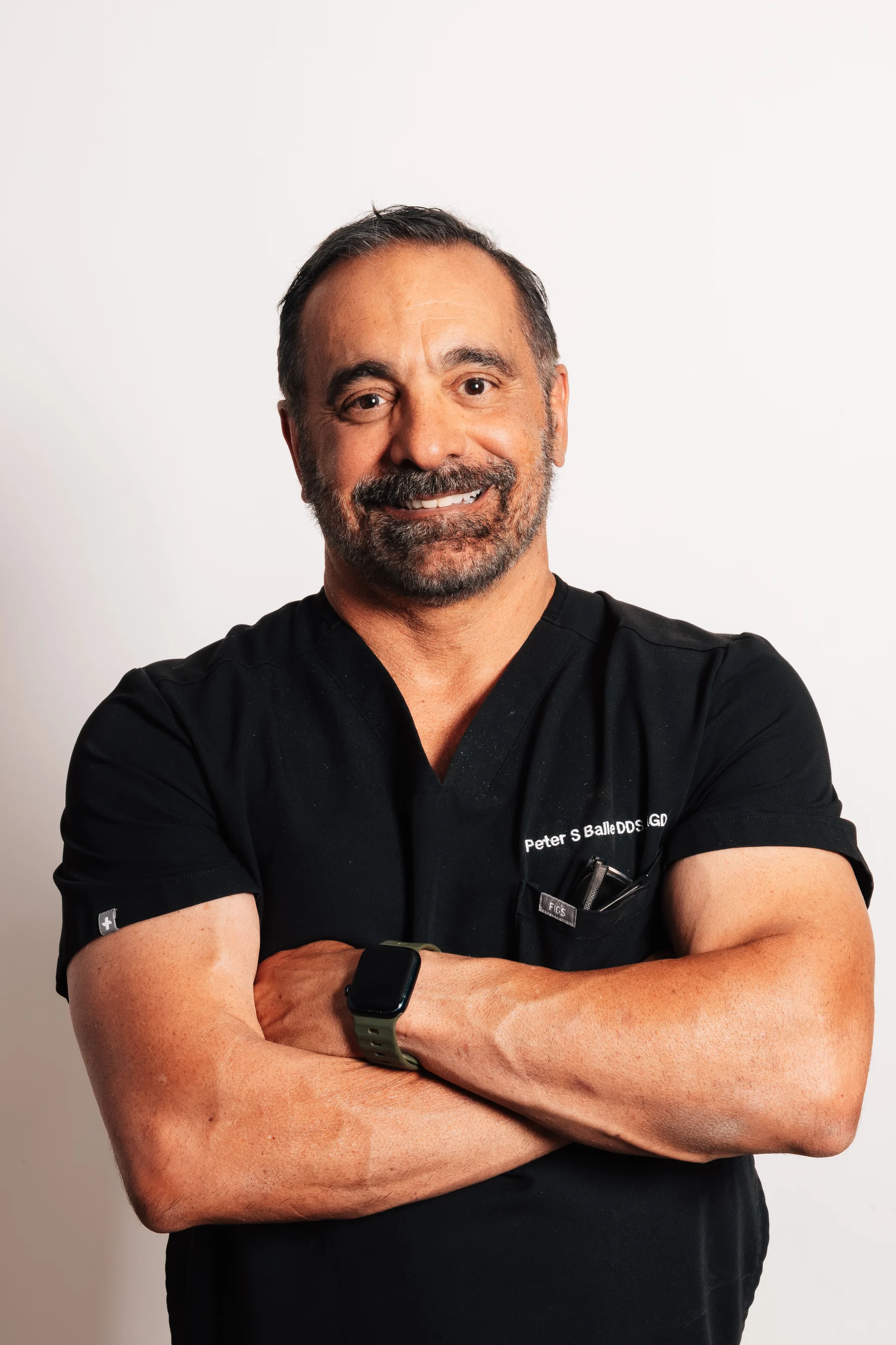 Dr. Peter S. Balle, DDS, FAGD, standing with arms crossed
